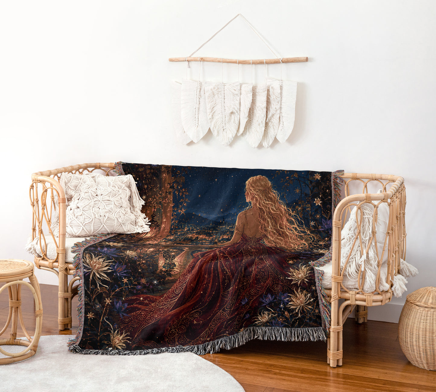 a cozy living room with a large woven blanket featuring a woman in a red dress sitting on a bench, gazing out a window. The blanket is draped over the bench, creating a warm and inviting atmosphere. The room is decorated with a rustic touch, including a woven basket and a hanging feather wall art piece.