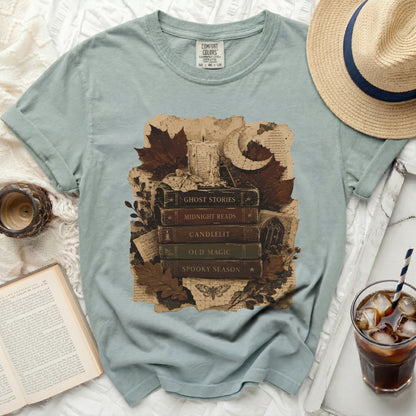T-shirt graphic with stacked books titled Ghost Stories, Midnight Reads, Old Magic, Spooky Season.