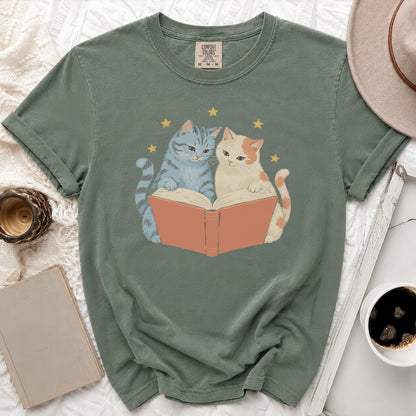 Green t-shirt with two cats reading a book with stars