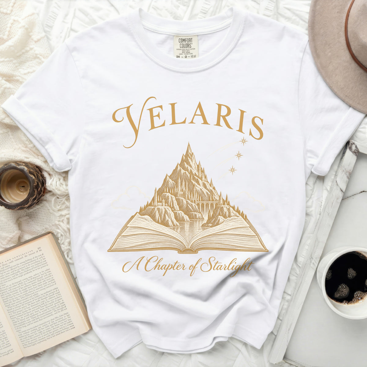 White Comfort Colors t-shirt with gold "Velaris" and "A Chapter of Starlight" design.
