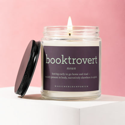 A lit glass candle with a purple label that reads "booktrovert" and its definition.