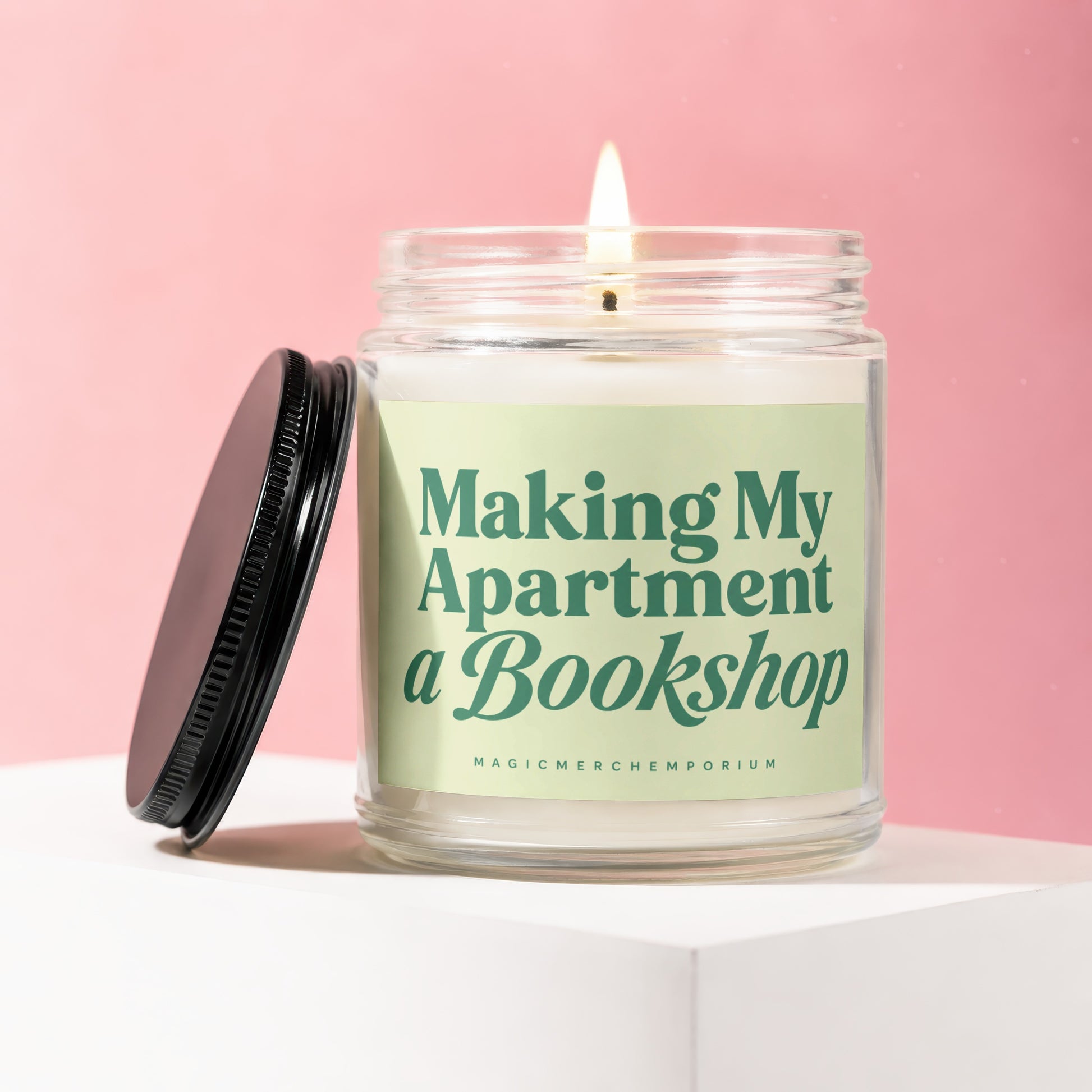 Glass candle with lit wick, featuring "Making My Apartment a Bookshop" text.