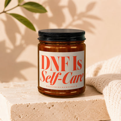 Brown glass candle with white label reading "DNF Is Self-Care".