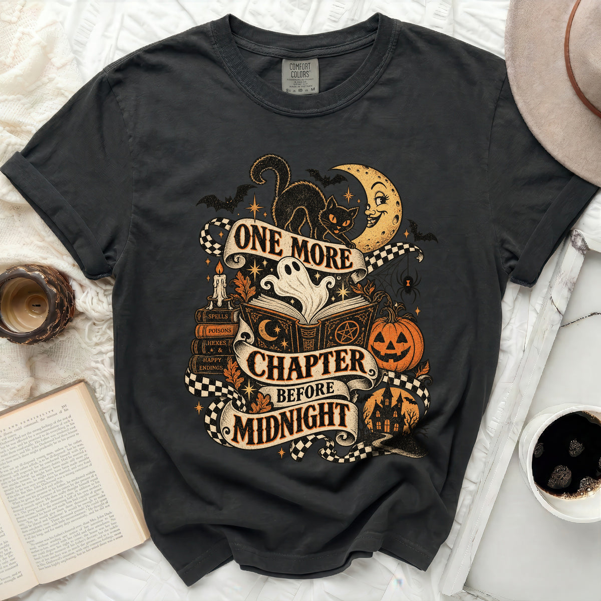 Black t-shirt with Halloween graphic: black cat, ghost, moon, books, and "One More Chapter Before Midnight".