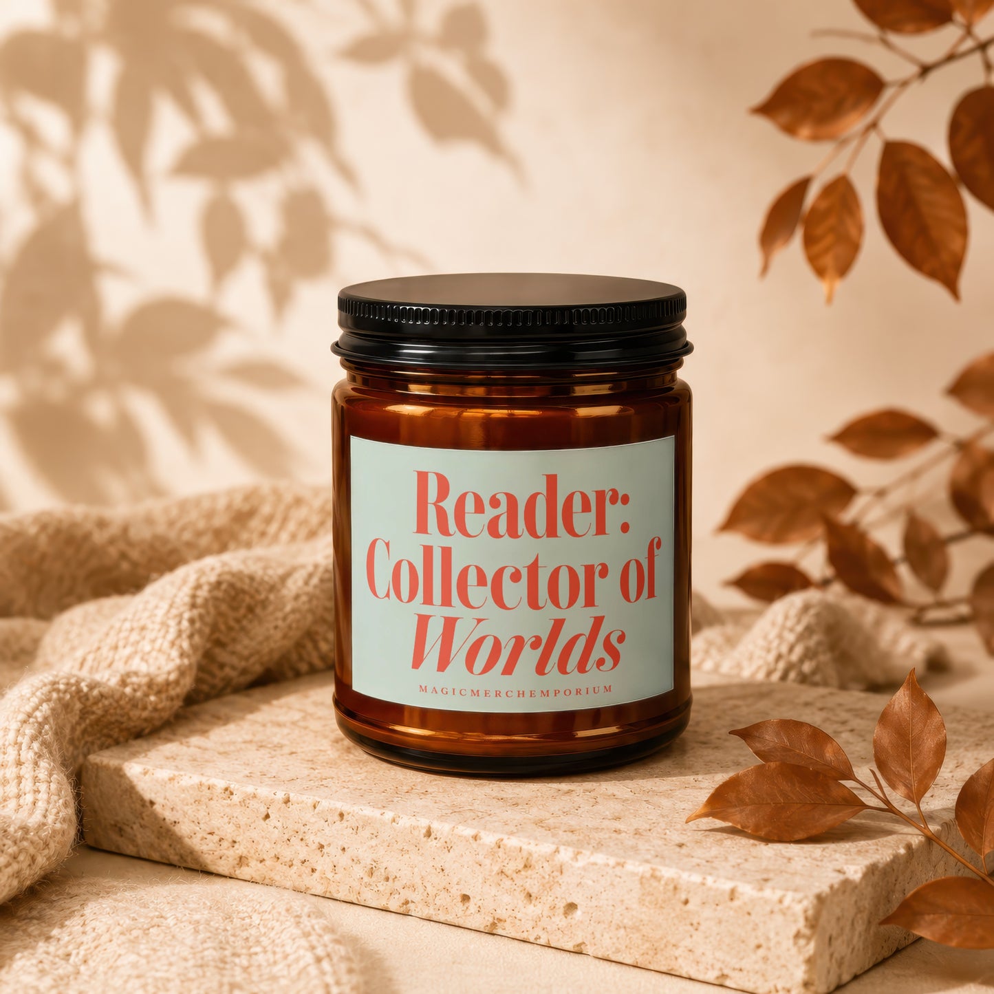 Amber candle with a cream label reading "Reader: Collector of Worlds".