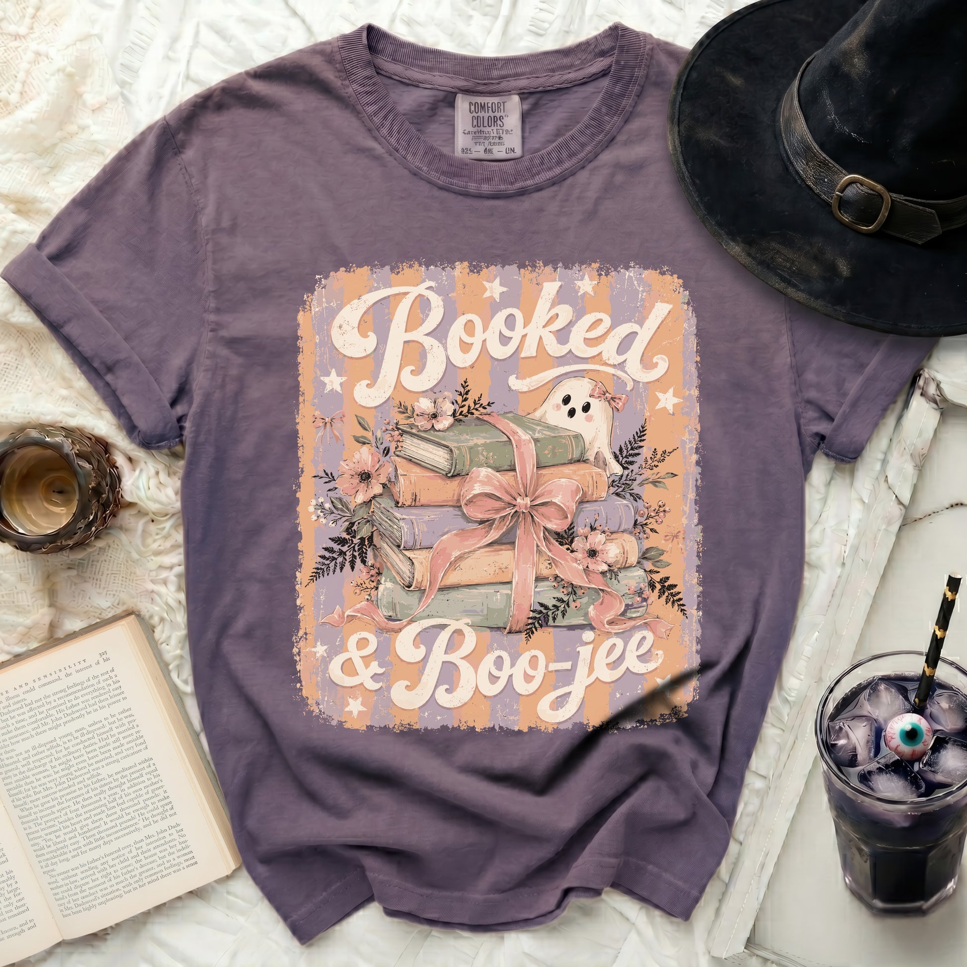 Purple t-shirt with "Booked & Boo-jee" Halloween graphic of books, ghost, and flowers.