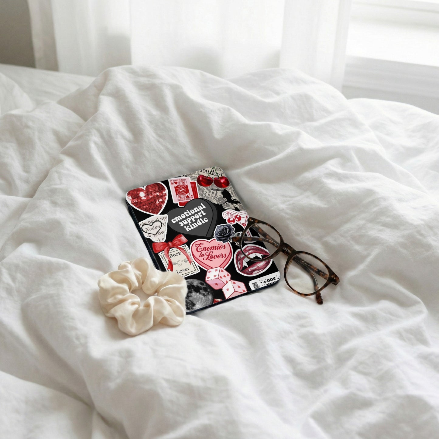 Kindle e-reader with various stickers like hearts, dice, and text.