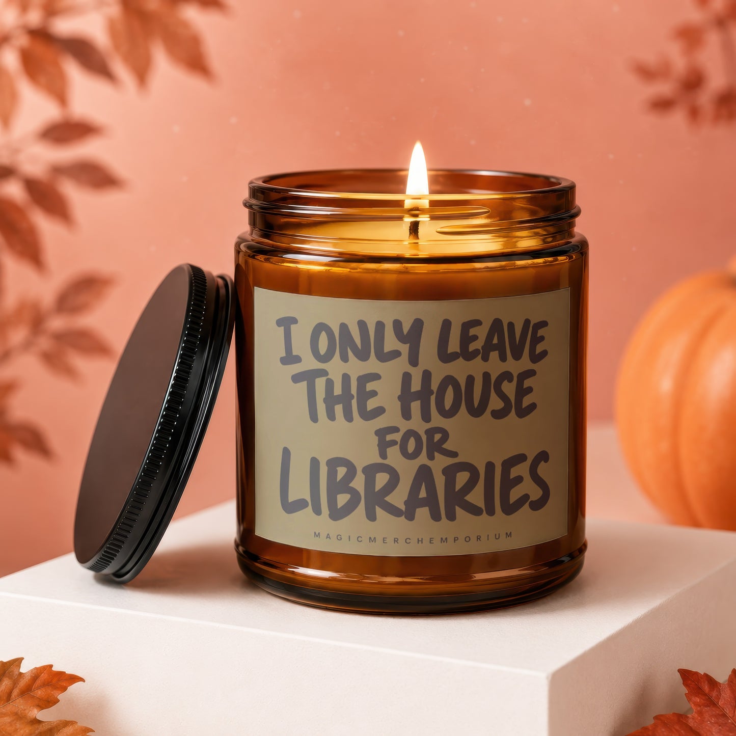 Amber glass candle with "I ONLY LEAVE THE HOUSE FOR LIBRARIES" text, lid detached.