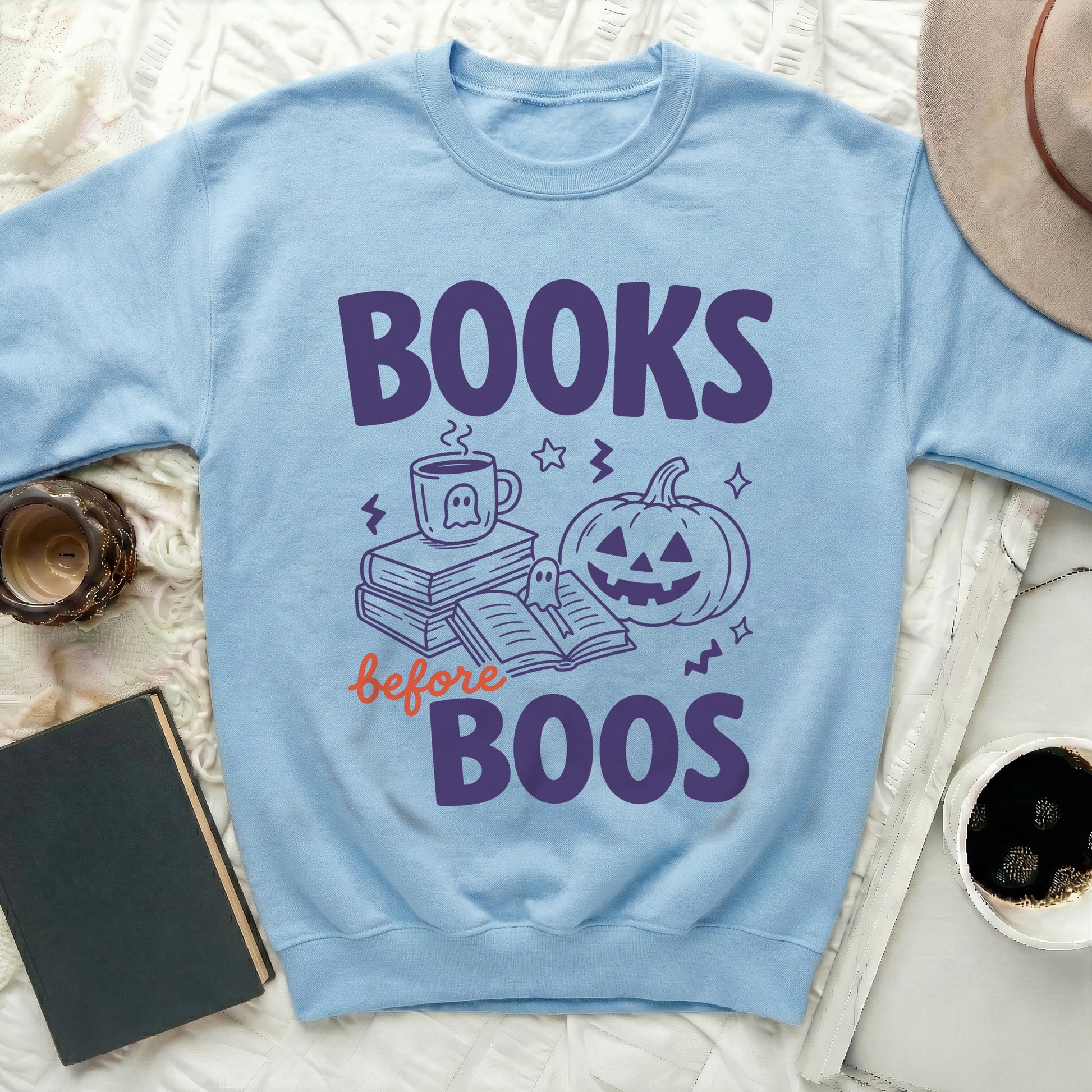 Light blue sweatshirt with "Books before Boos" Halloween graphic.