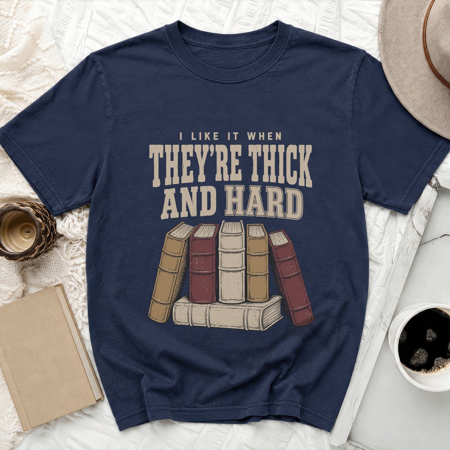 Navy t-shirt with text "I LIKE IT WHEN THEY'RE THICK AND HARD" above stacked books.