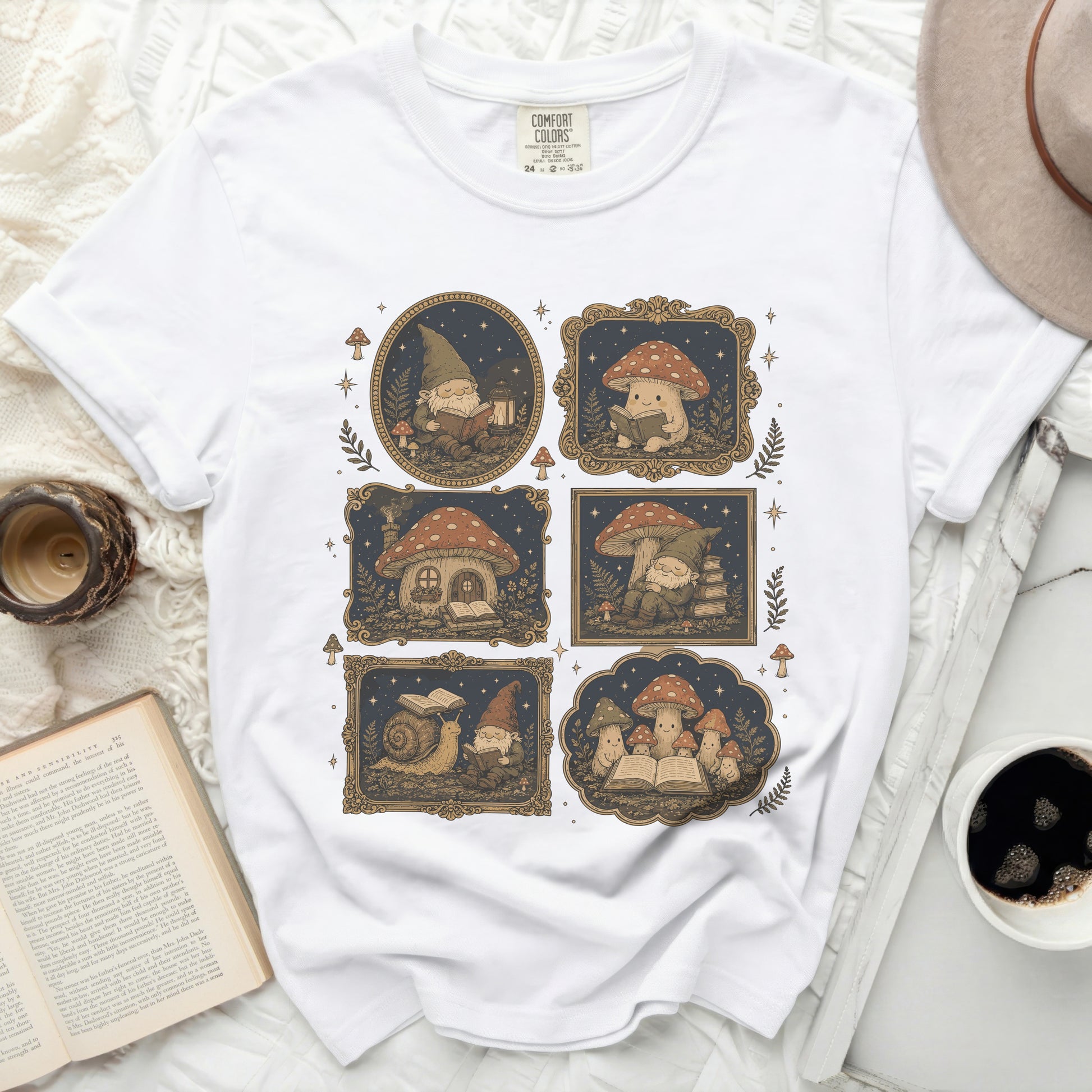 White crewneck t-shirt featuring a repeating graphic of gnomes, mushrooms, and snails reading books.
