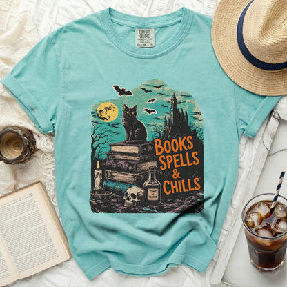 Mint green t-shirt with black cat, spellbook, skull, and "Books Spells & Chills" design.