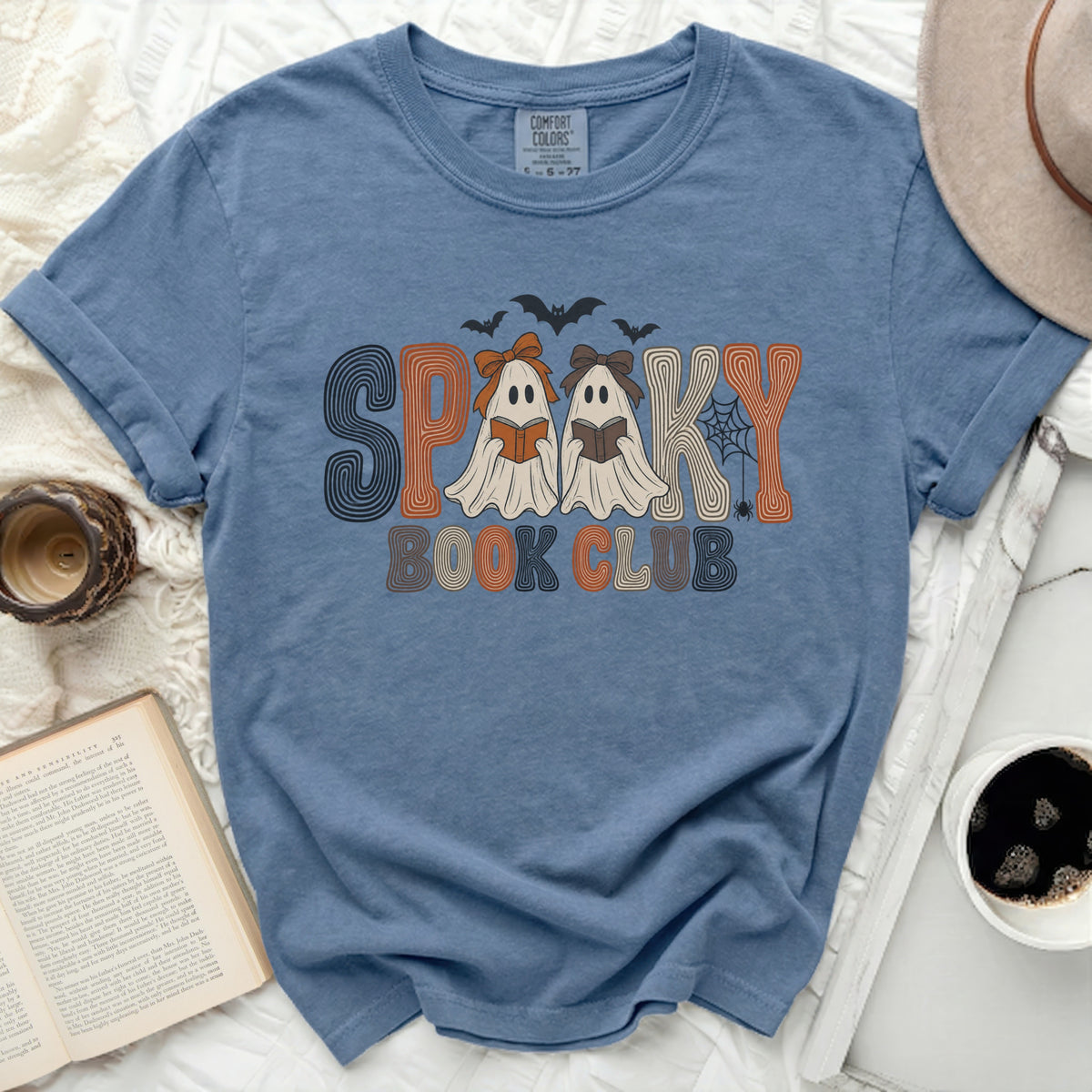Blue t-shirt with "Spooky Book Club" graphic featuring ghosts, bats, and a spiderweb.