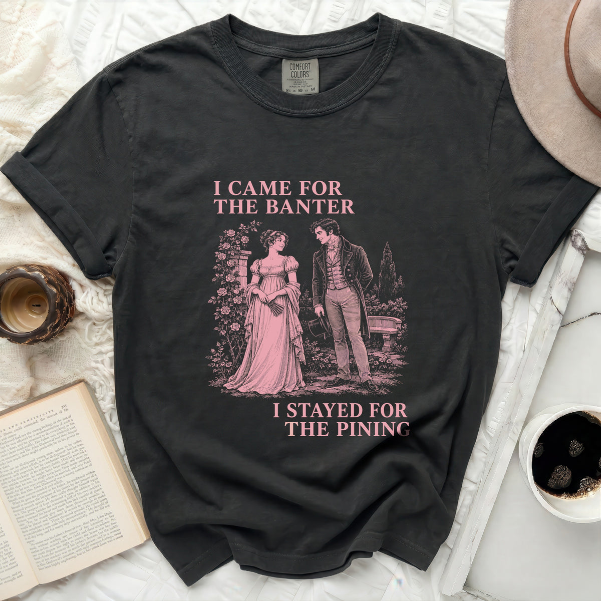 Dark grey t-shirt with pink text and illustration of a couple in period clothing.