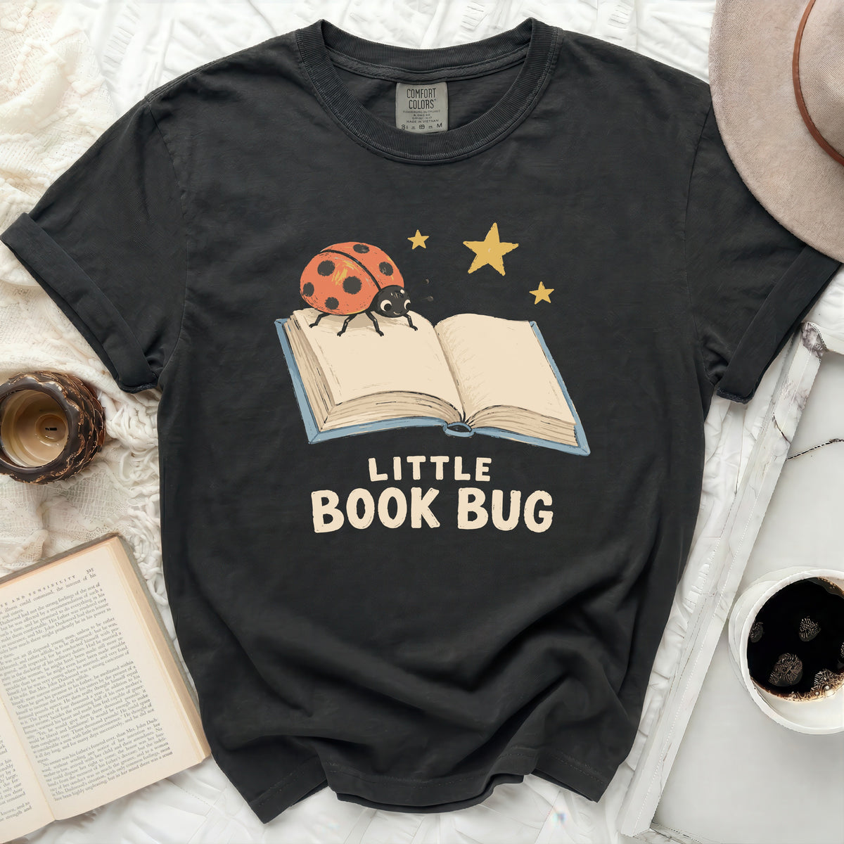Black t-shirt with a ladybug on an open book and text "Little Book Bug".