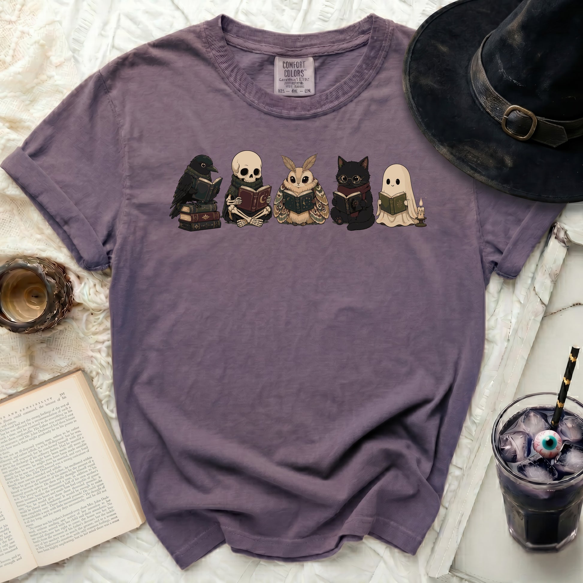 T-shirt with a graphic of a crow, skeleton, moth, cat, and ghost reading books