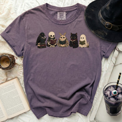 T-shirt with a graphic of a crow, skeleton, moth, cat, and ghost reading books