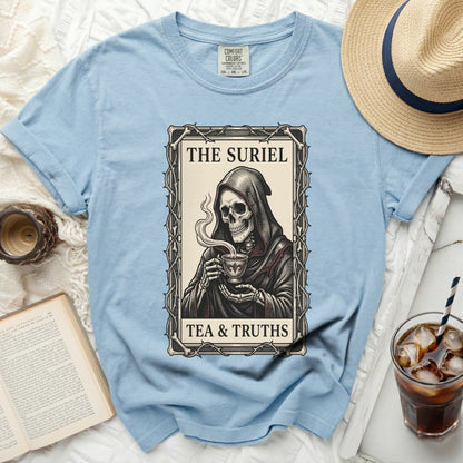 Light blue t-shirt with a grim reaper holding a teacup graphic and text "THE SURIEL TEA & TRUTHS".
