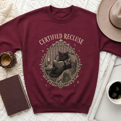 Maroon sweatshirt with "Certified Recluse" text and a black cat reading a book.