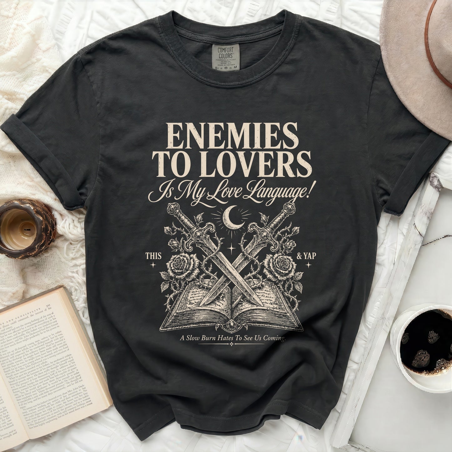 Black t-shirt with "Enemies to Lovers is My Love Language" text and crossed swords over a book.
