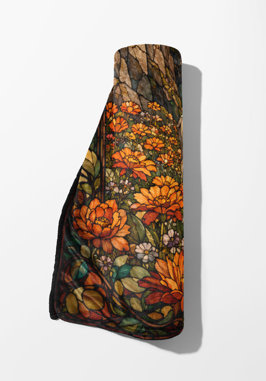Rolled blanket with stained-glass floral pattern featuring orange and yellow flowers.