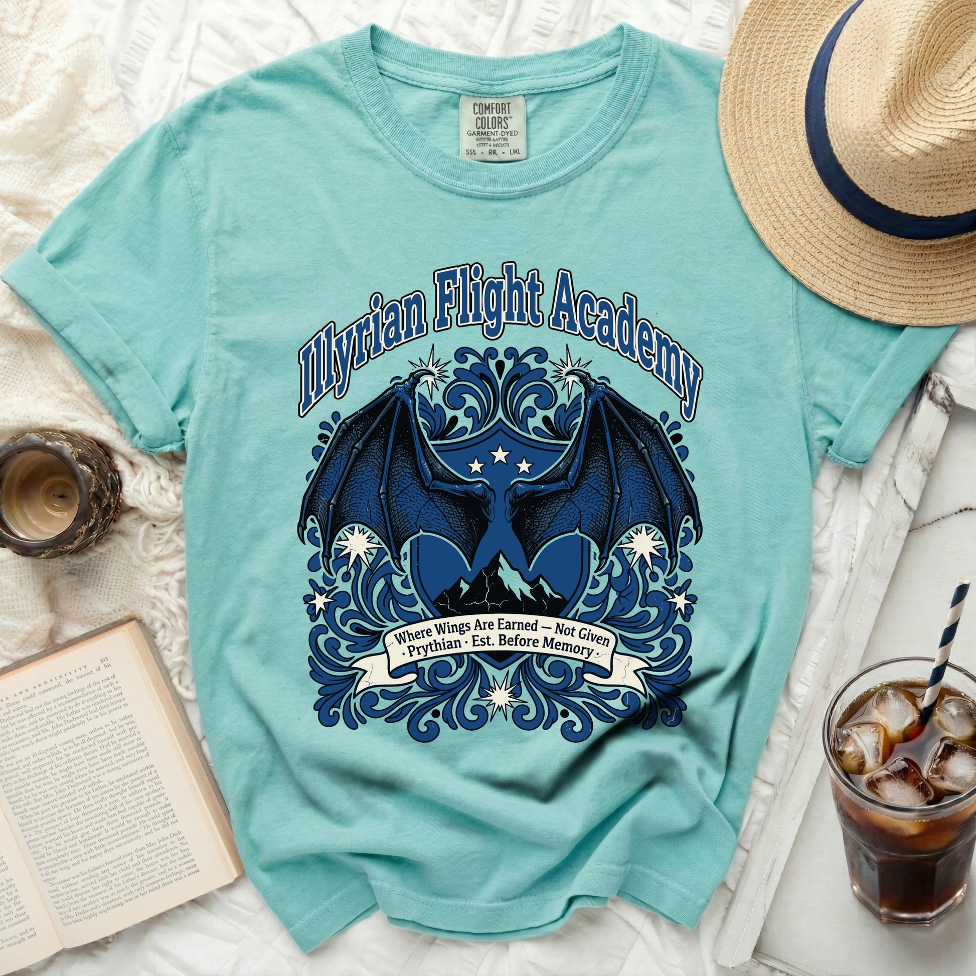 Aqua t-shirt with "Myrian Flight Academy" text, dragon wings, mountains, and banner.