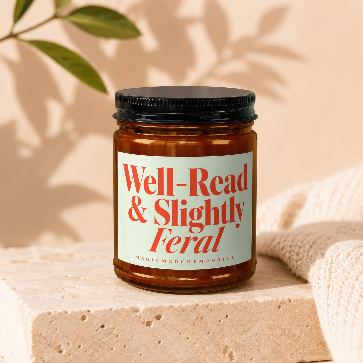 Amber jar candle with "Well-Read & Slightly Feral" label and "MagicMerchEmporium" text.