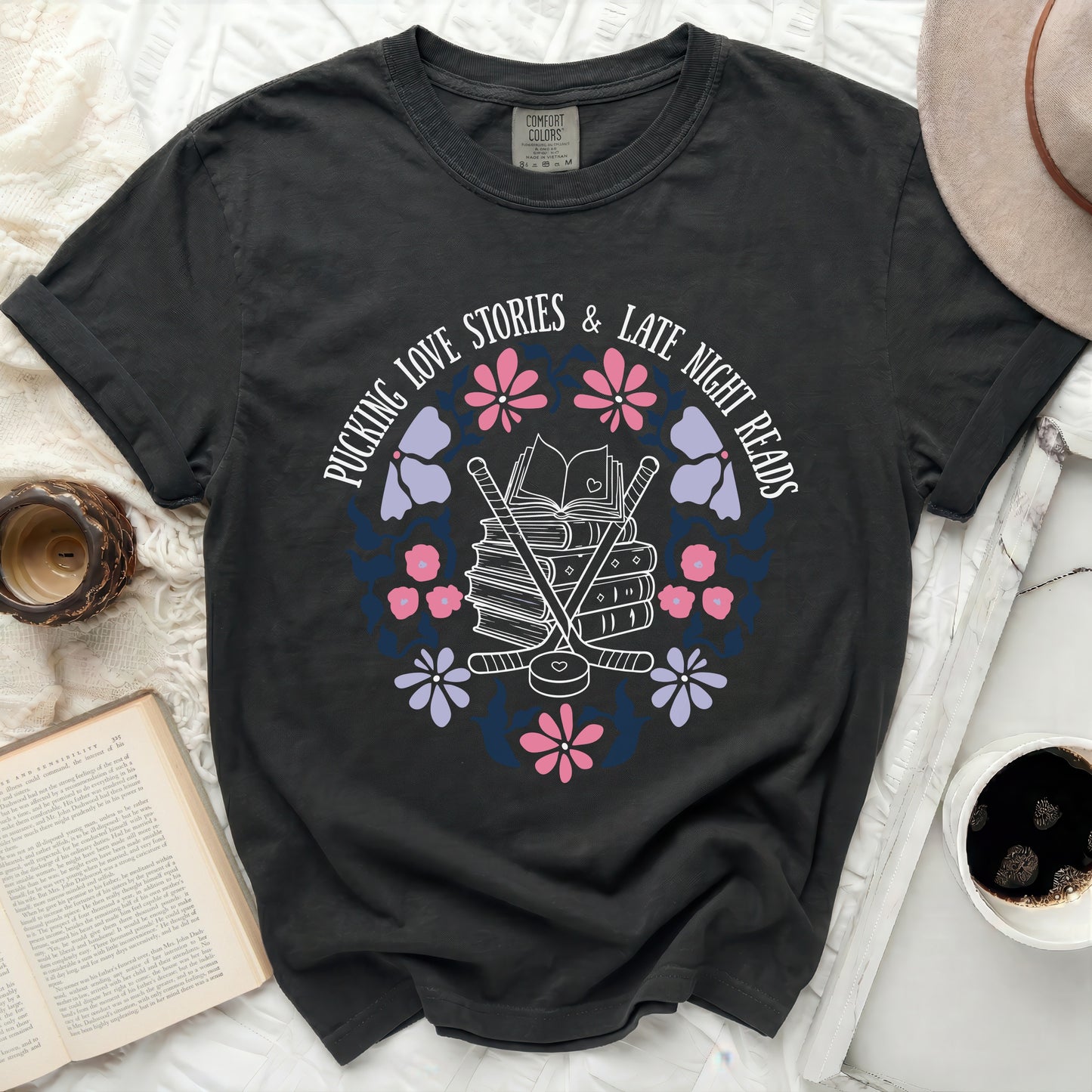 Dark t-shirt with "Pucking love stories & late night reads" text and floral hockey design.