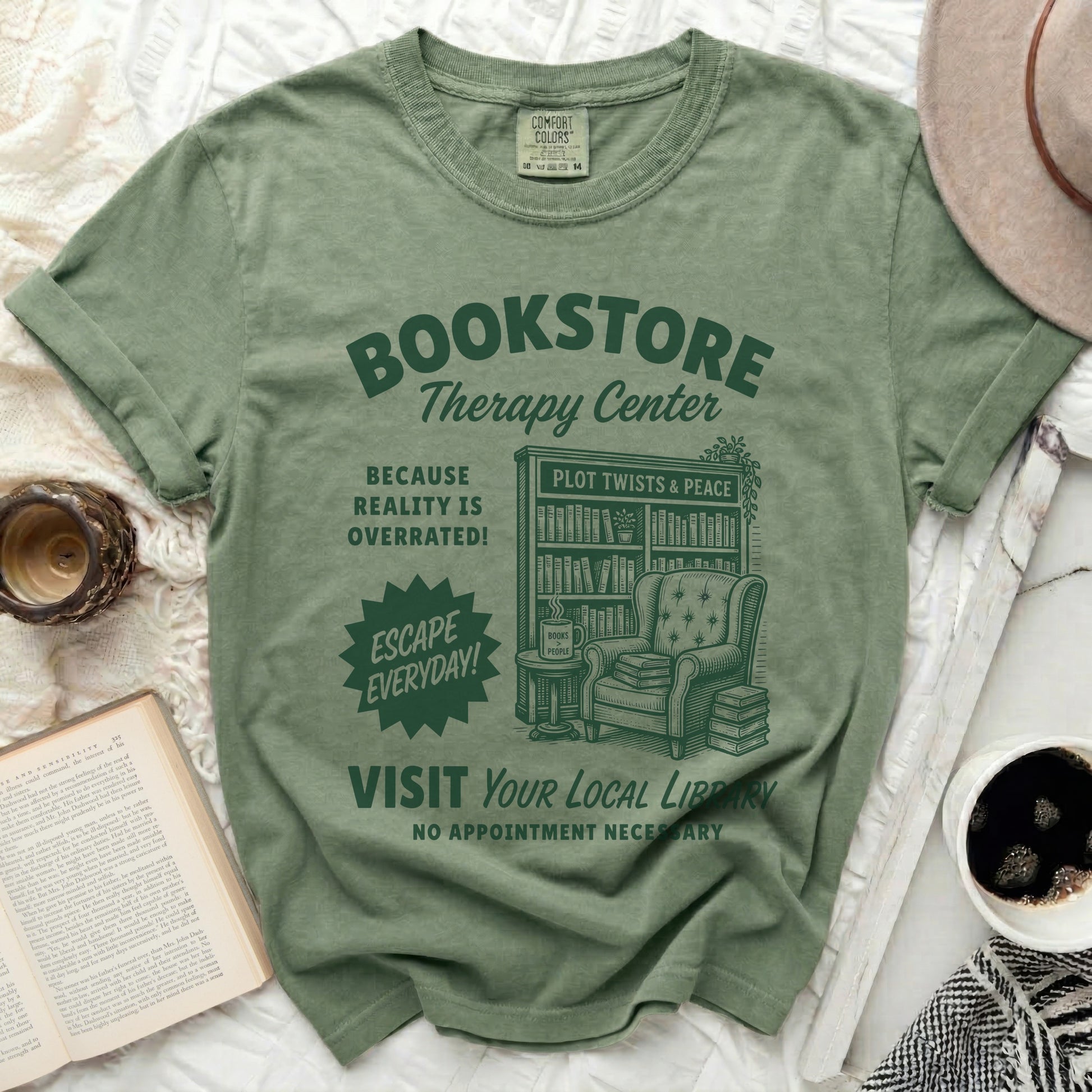 Green t-shirt with "Bookstore Therapy Center" graphic and armchair illustration.