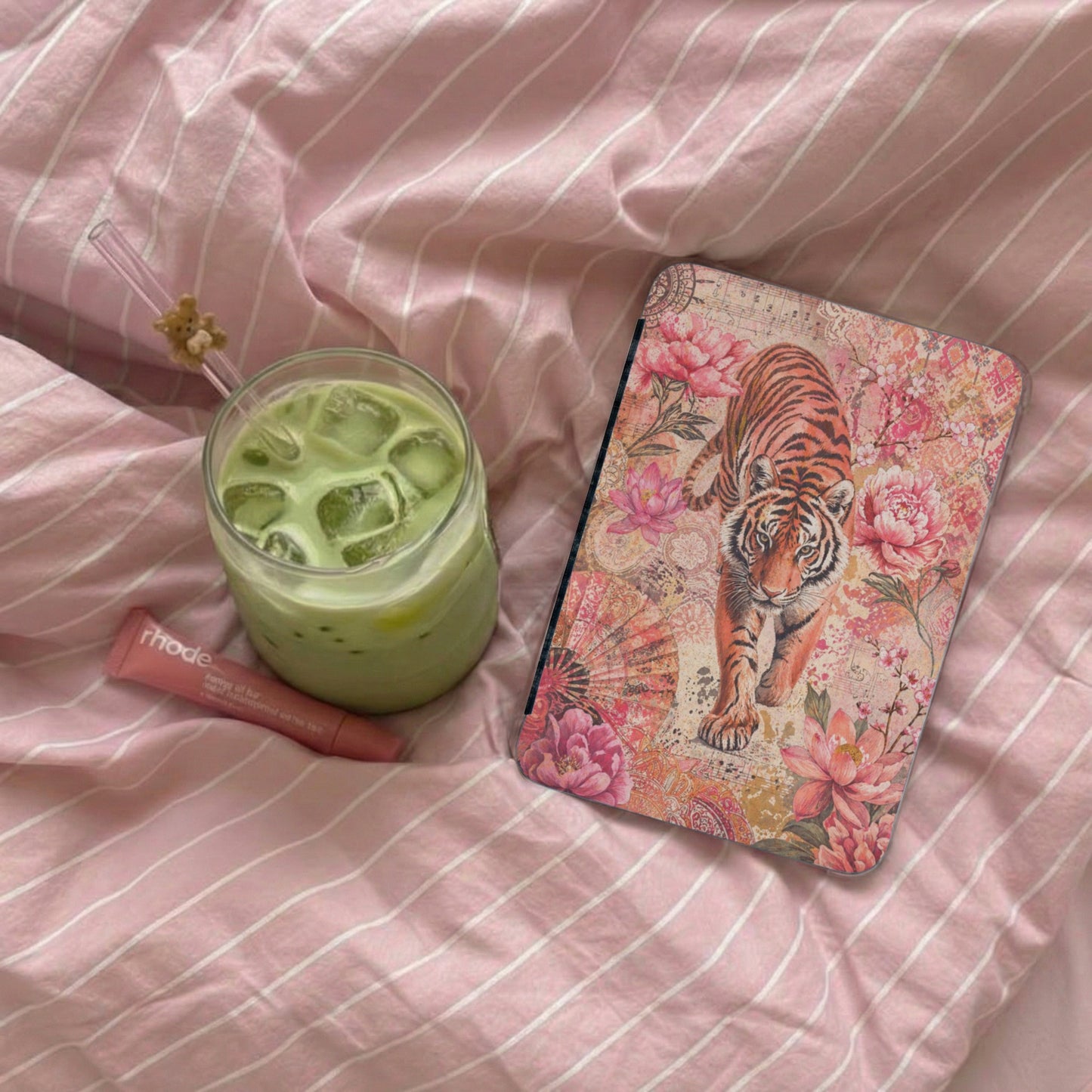 Tablet cover with tiger print and floral design on pink striped background.