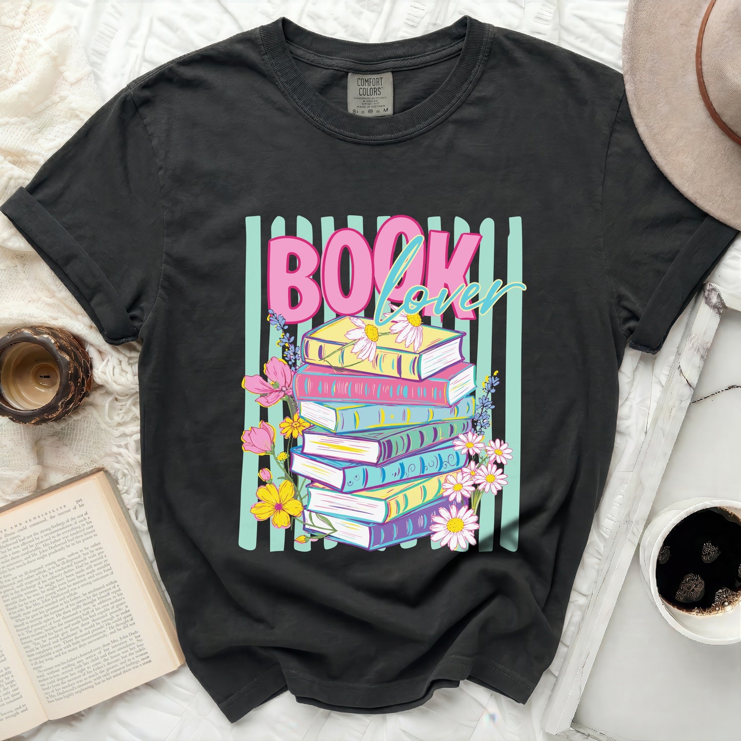 Dark t-shirt with "BOOK lover" graphic and stack of colorful books.