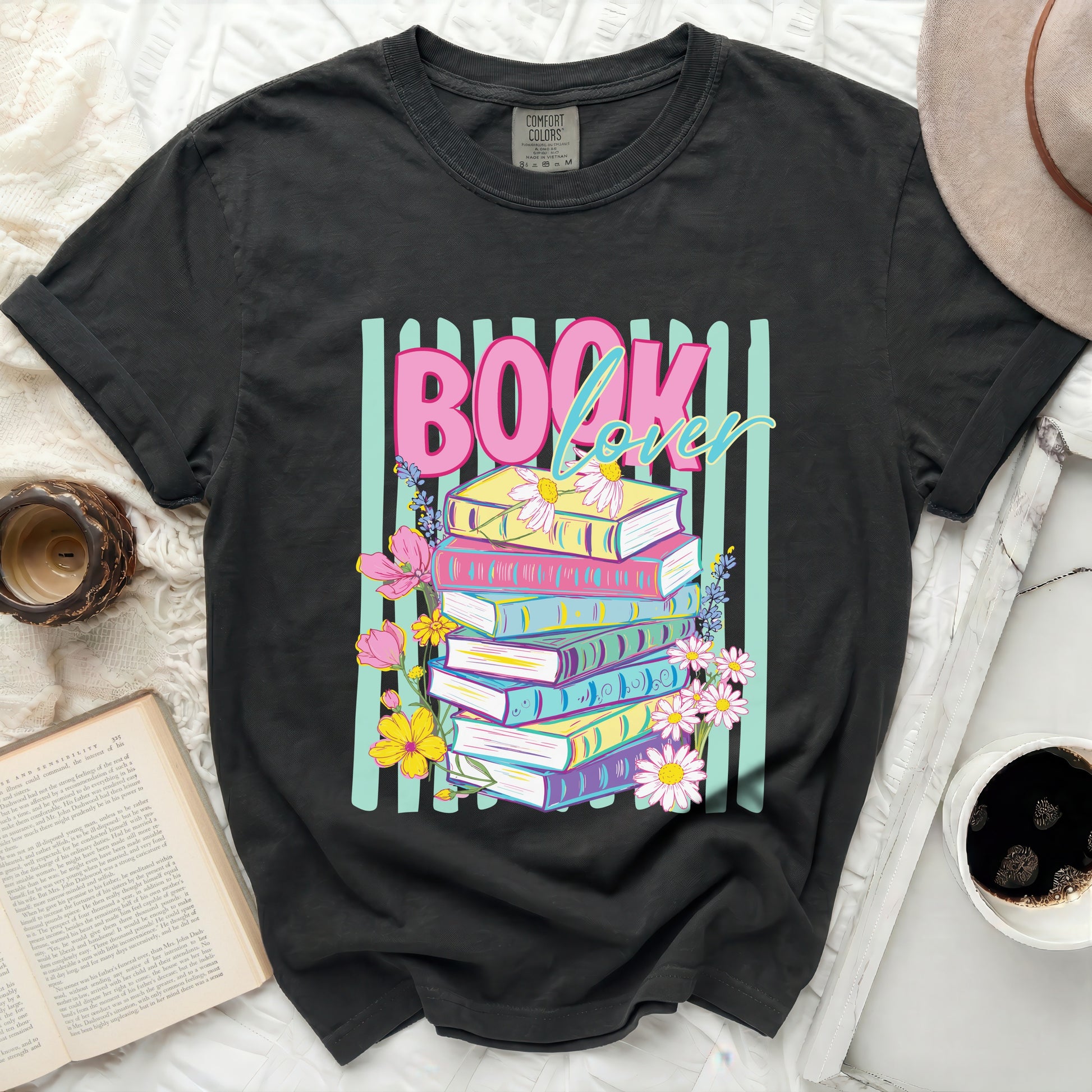 Dark t-shirt with "BOOK lover" graphic and stack of colorful books.