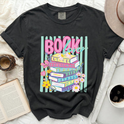 Dark t-shirt with "BOOK lover" graphic and stack of colorful books.