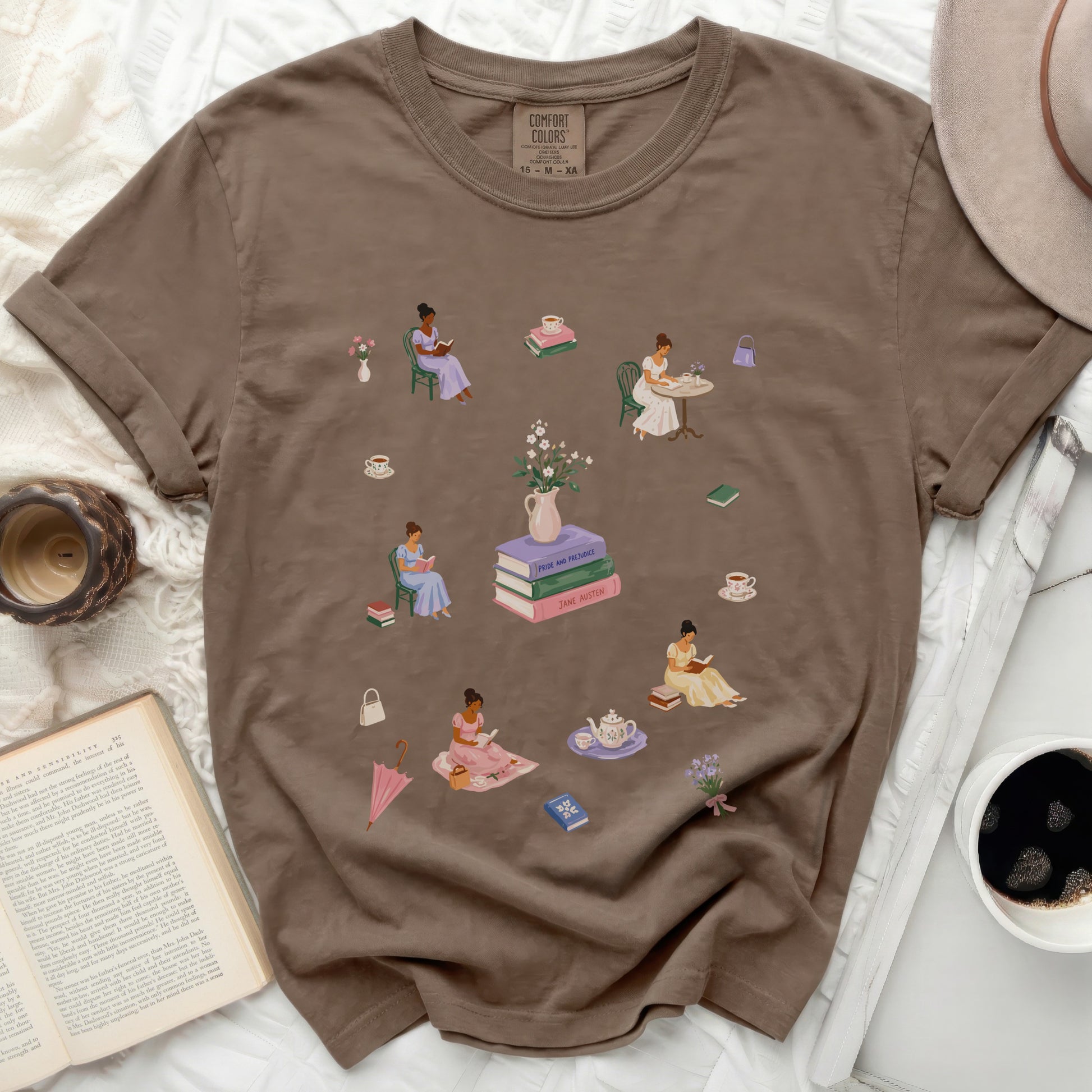 Brown t-shirt with scattered illustrations of women reading, sipping tea, and books.