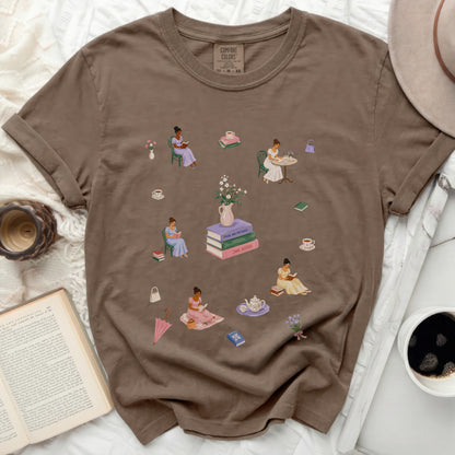 Brown t-shirt with scattered illustrations of women reading, sipping tea, and books.