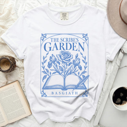 White t-shirt with blue "The Scribe's Garden Basgiath" design, featuring a rose and open book.
