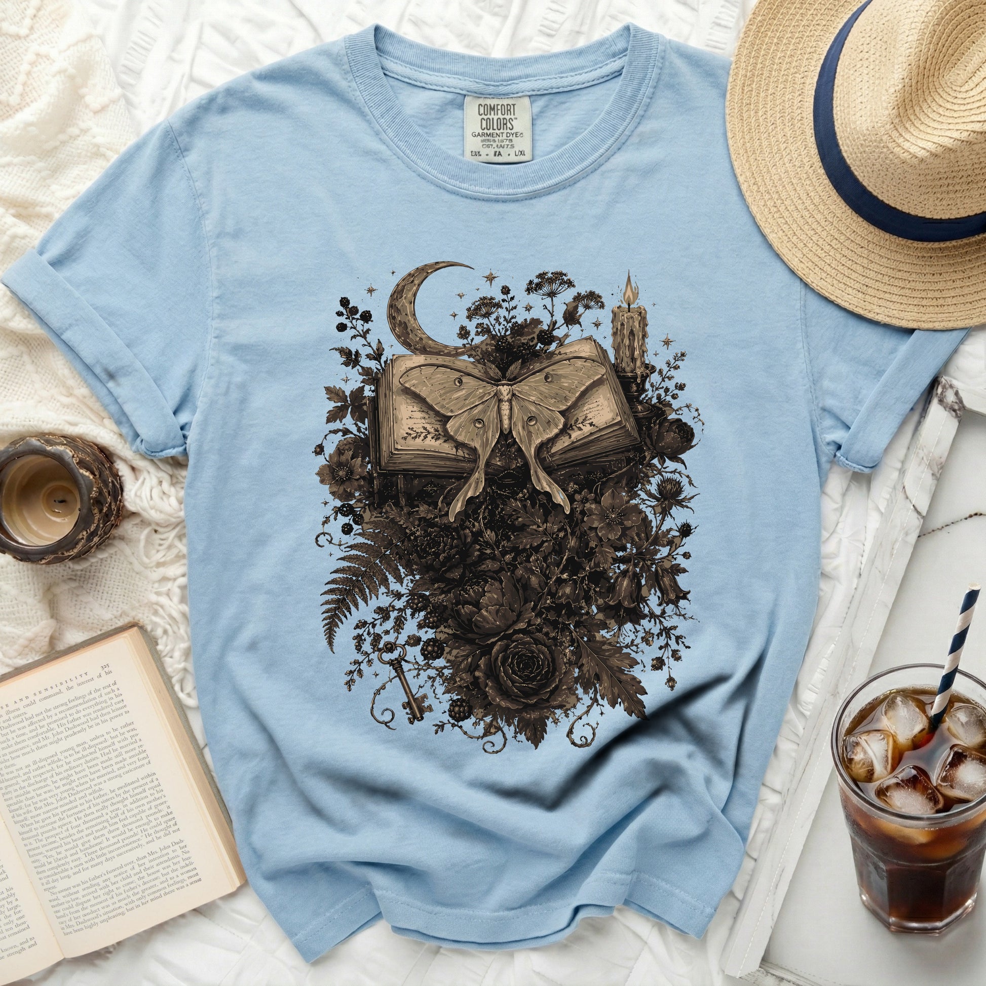 Light blue comfort colors t-shirt with moth and book graphic.