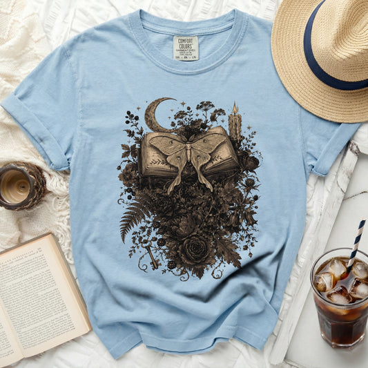 Light blue comfort colors t-shirt with moth and book graphic.
