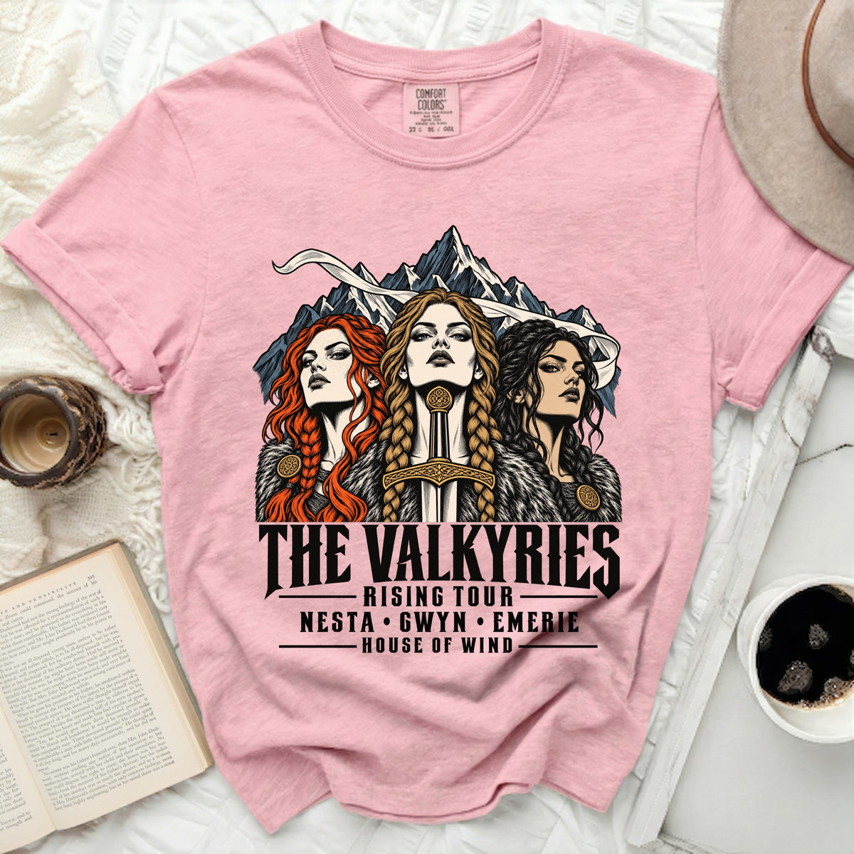 Pink t-shirt with artwork of three Valkyries and text "The Valkyries Rising Tour Nesta Gwyn Emerie House of Wind".