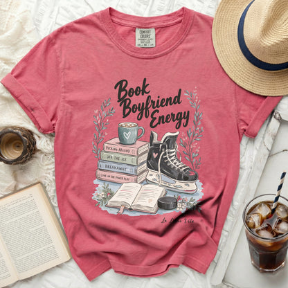 Pink t-shirt with "Book Boyfriend Energy" text and ice skate illustration.