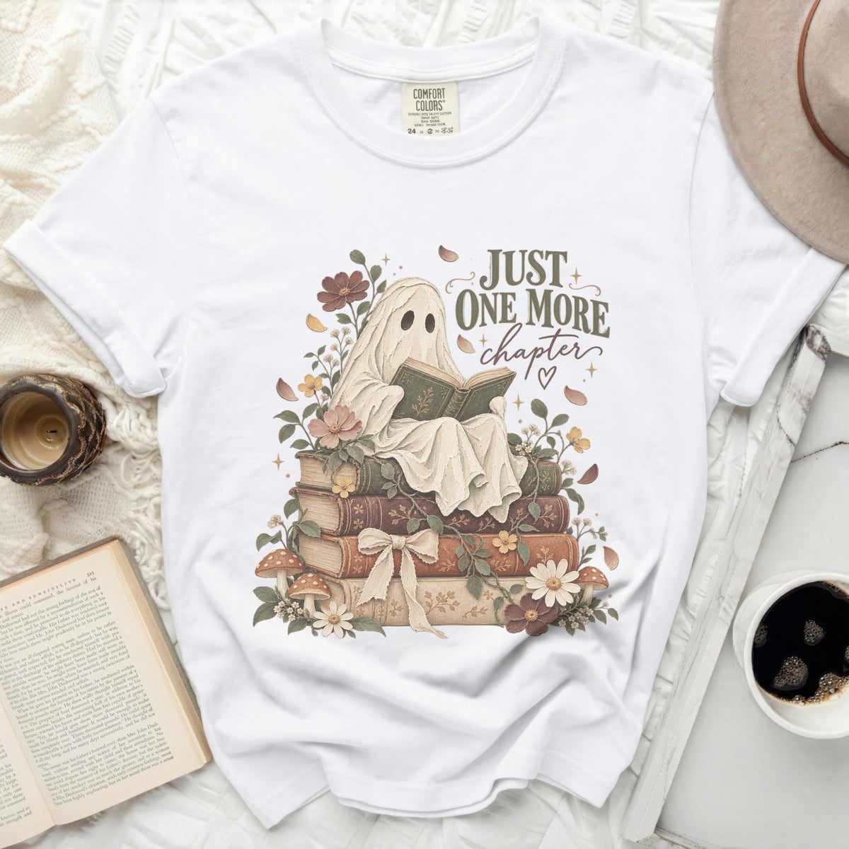 White t-shirt with ghost reading "Just One More Chapter" on books.