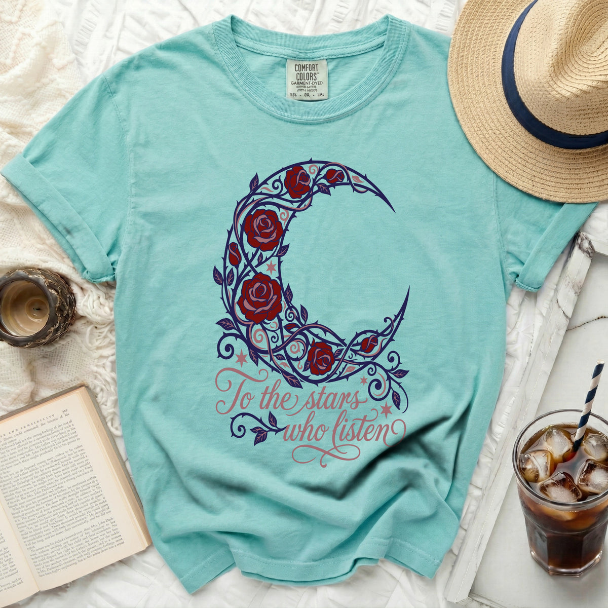 Teal t-shirt with crescent moon floral design and "To the stars who listen" text.