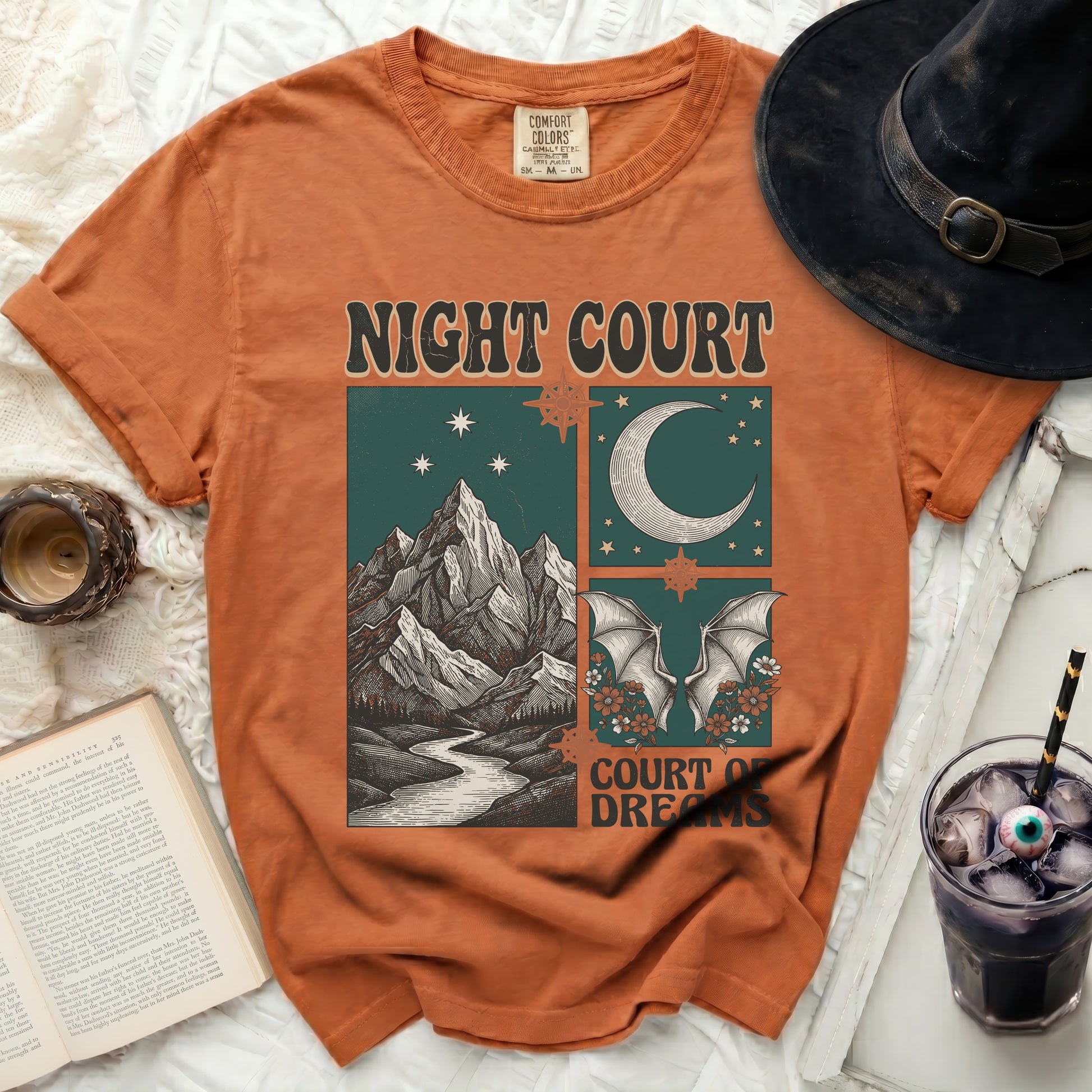 Orange t-shirt with "Night Court Court of Dreams" graphic of mountains, moon, and bats.