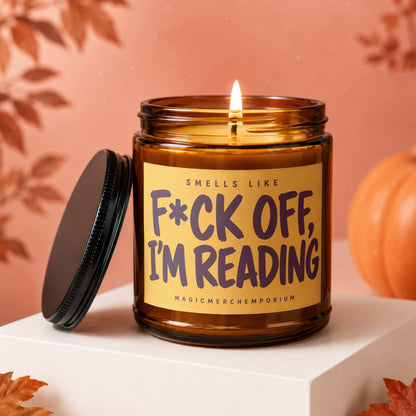 Amber glass candle with black lid and label reading "F*CK OFF, I'M READING."