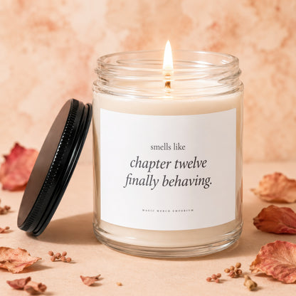 Candle with "Smells like chapter twelve finally behaving" text and black lid.