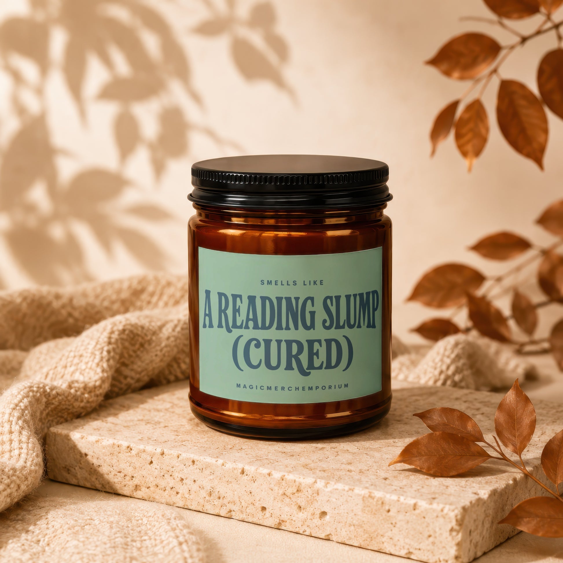 Amber candle with a light green label reading "Smells Like A Reading Slump (Cured)".