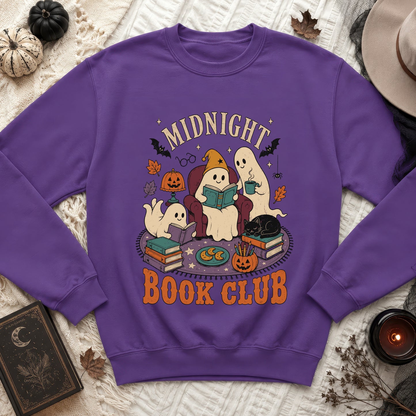 Purple sweatshirt with a "Midnight Book Club" Halloween graphic featuring ghosts reading and a black cat.