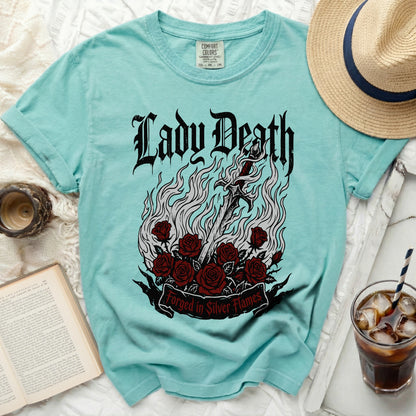 Turquoise t-shirt with "Lady Death Forged in Silver Flames" gothic graphic.