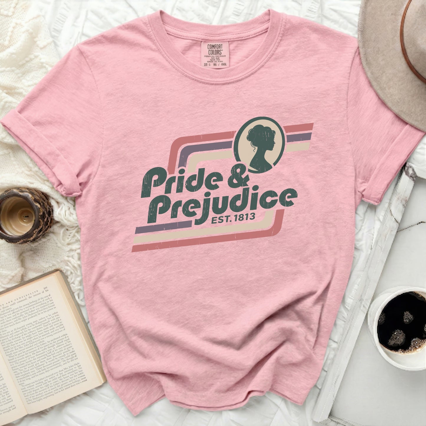 Pink t-shirt with "Pride & Prejudice Est. 1813" graphic and silhouette.