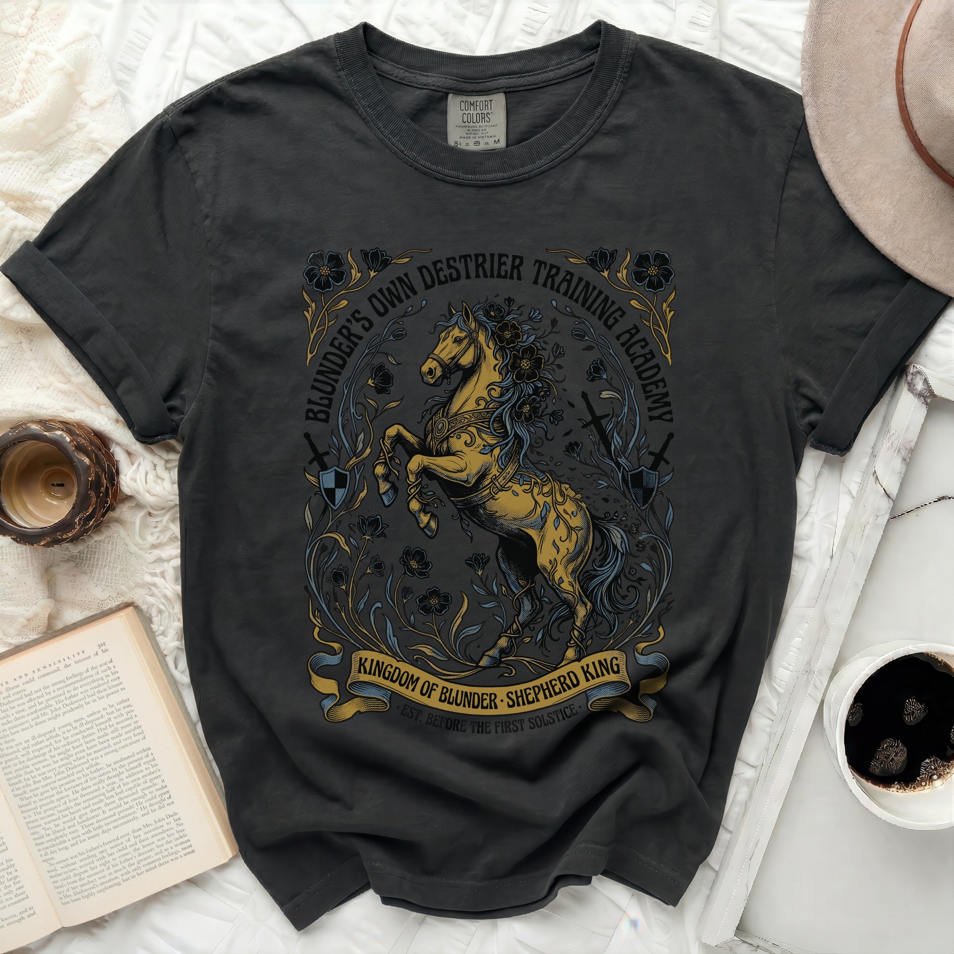 Black t-shirt with "Blunder's Own Destrier Training Academy" and a golden horse graphic.